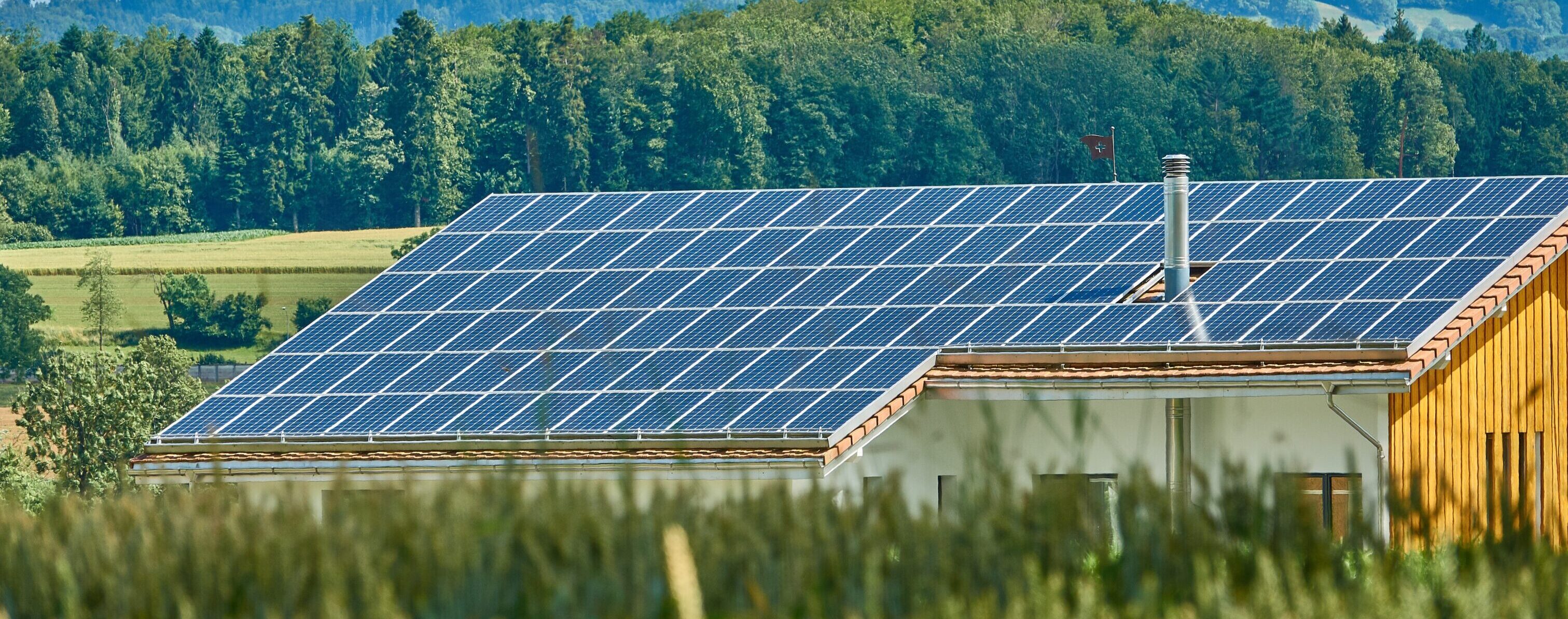 Scheune mit Solar Panals auf dem Dach in Naturumgebung bei Sonneschein inUnum AG